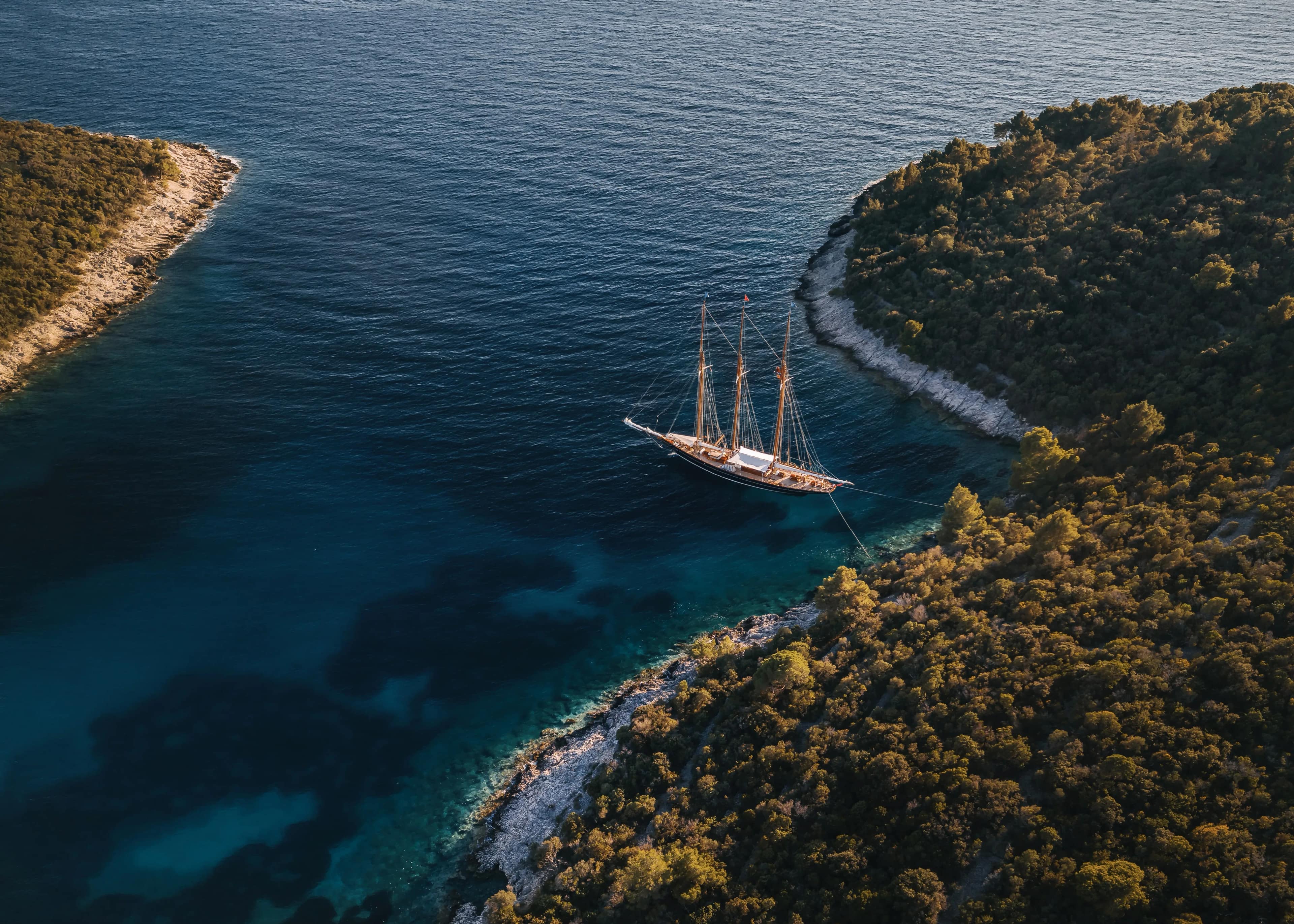 A gulet anchored between two forested islands