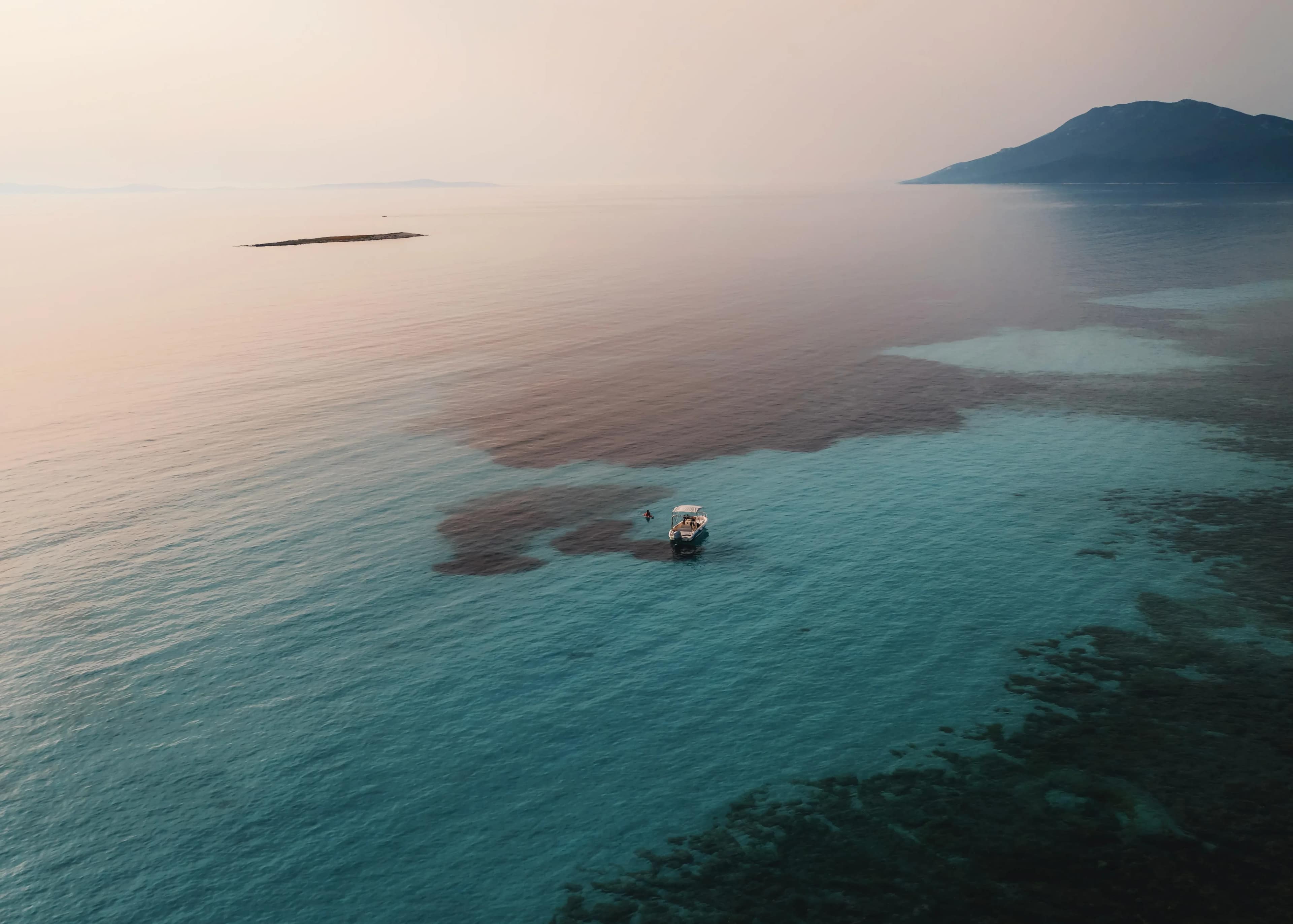 A small boat over the shallows at sunset
