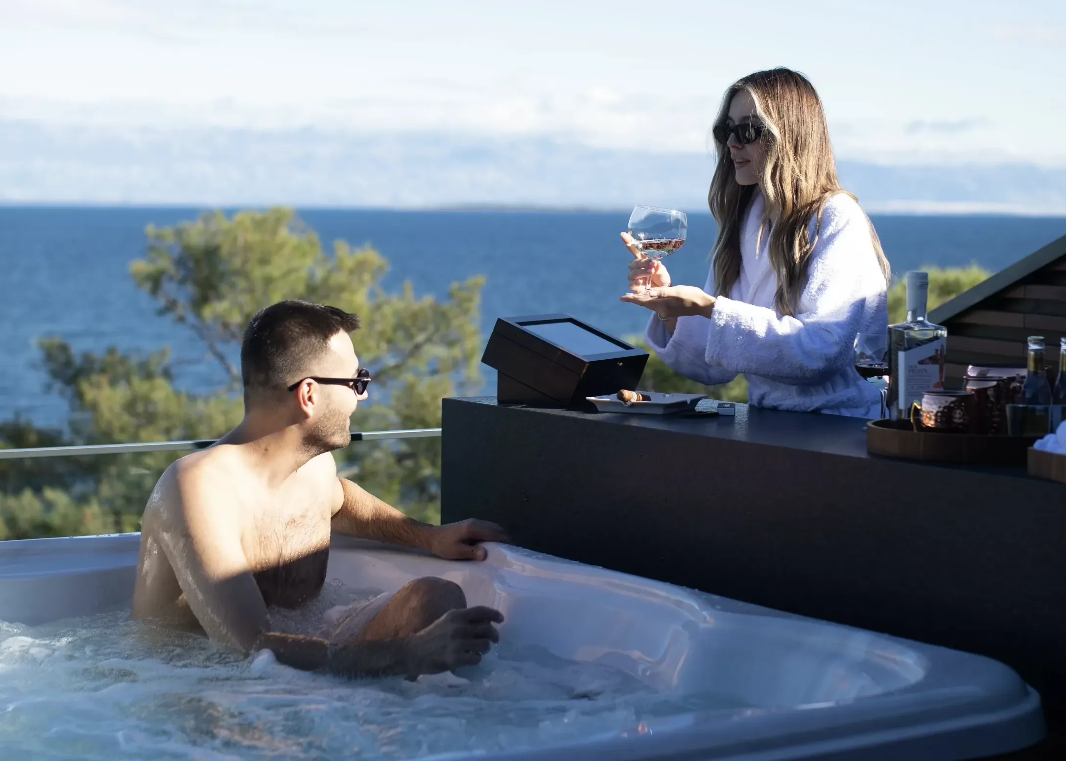 A couple in the rooftop hot tub, rosé in hand