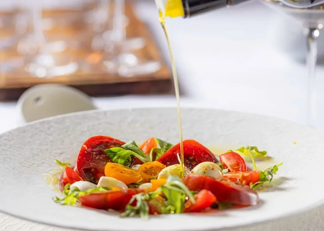 Olive oil poured over the tomato salad