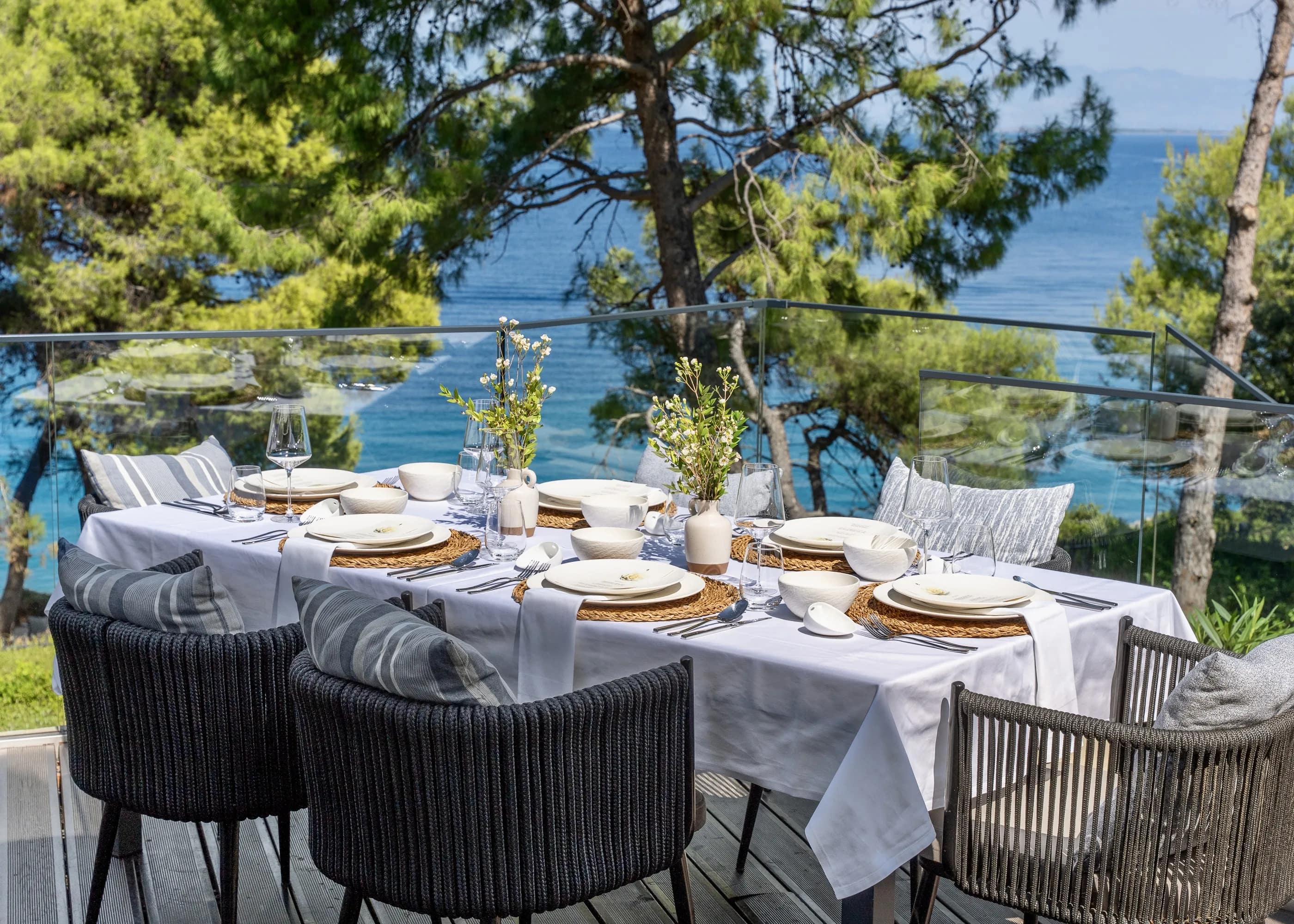 A table laid for six, the sea beyond it