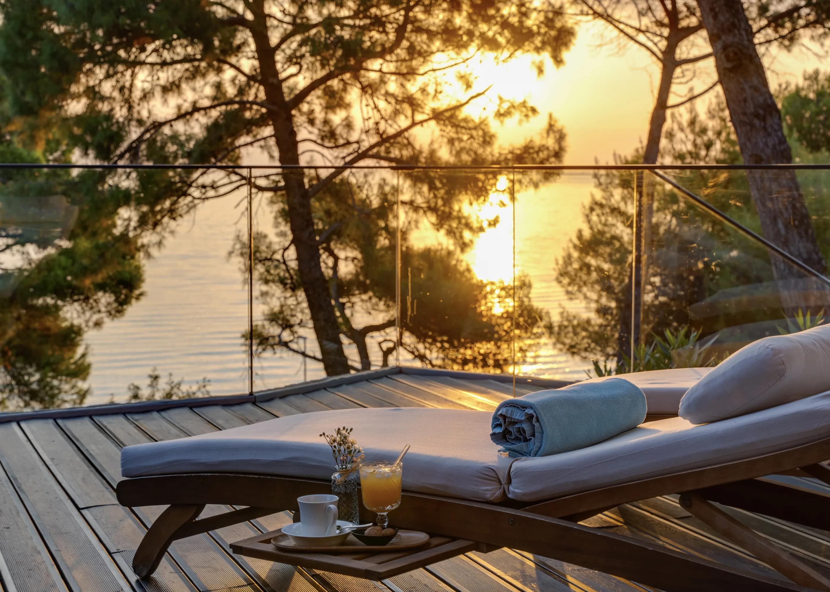 Two loungers on the deck at sunset, juice and coffee set out