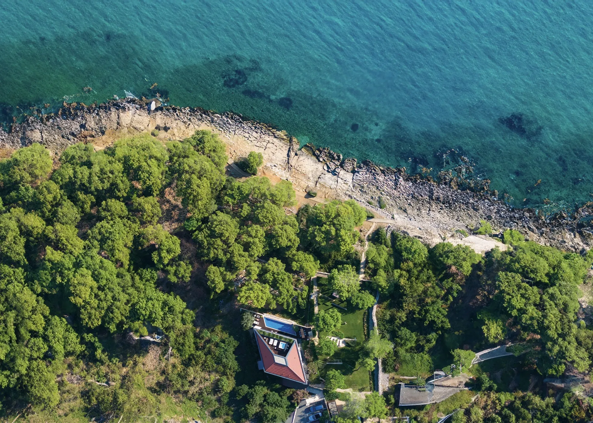 The villa and its grounds on the pine-covered coastline, from the air
