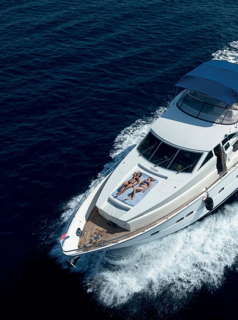 The 22-metre Horizon Elegance cruising the Adriatic, two guests on the bow sunbathing pad