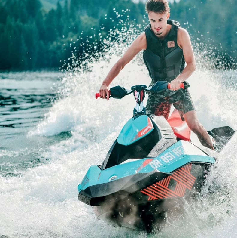 A jet-ski rider cutting spray across open water